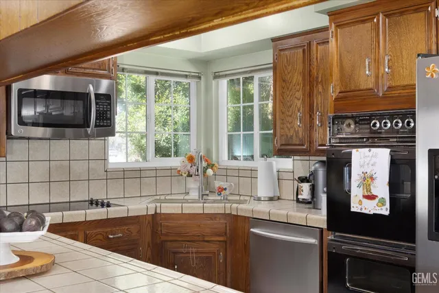 a kitchen with granite countertop a sink stainless steel appliances a counter space and cabinets
