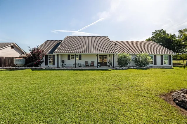 a front view of a house with swimming pool having outdoor seating