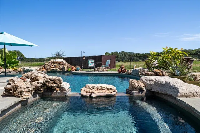 a view of a patio with table and chairs under an umbrella