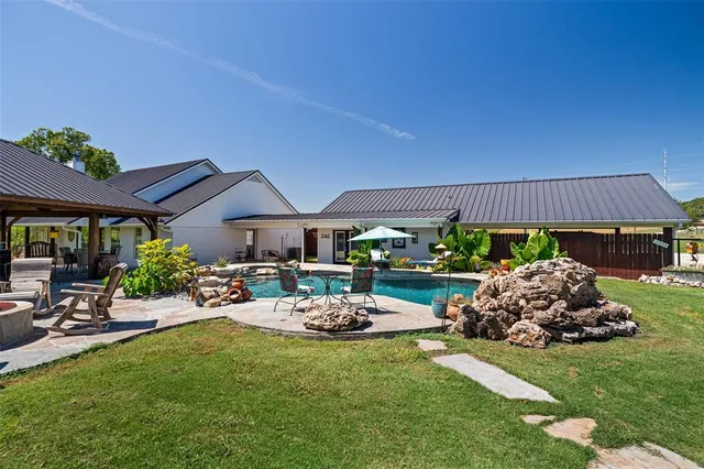 a view of swimming pool with outdoor seating and plants