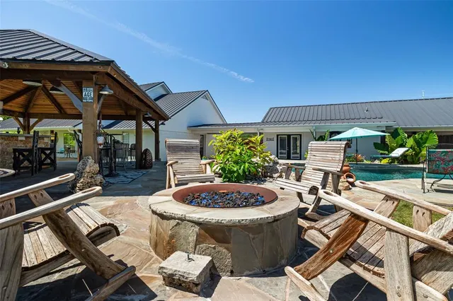 a view of a backyard with table and chairs potted plants and a wooden fence