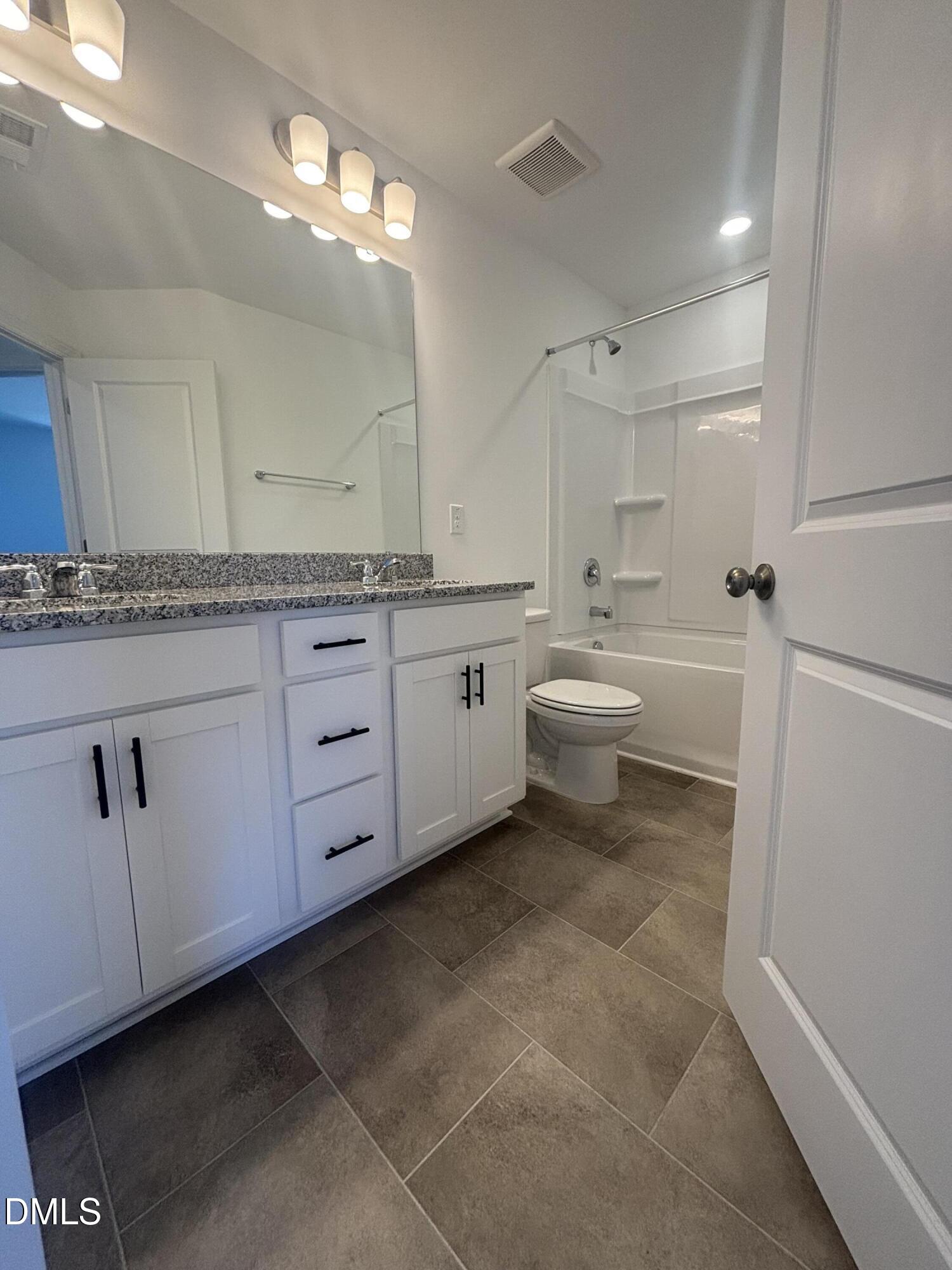 272 Hank Way Willow Spring, NC 27592 - Photo 19 of 19 a bathroom with a granite countertop sink a toilet and a mirror