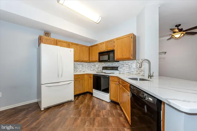 a kitchen with stainless steel appliances granite countertop a refrigerator sink and wooden cabinets