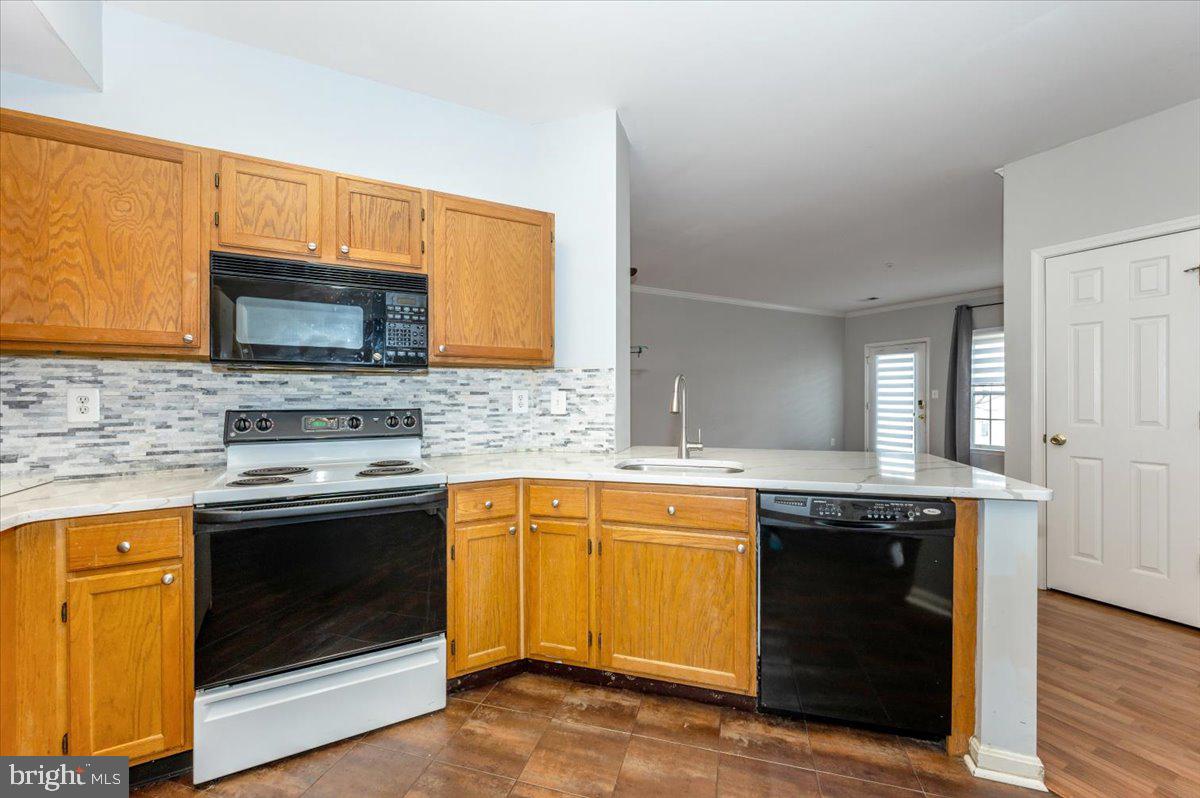 1683 Fallowfield Court Crofton, MD 21114 - Photo 14 of 36 a kitchen with granite countertop a stove top oven sink and cabinets