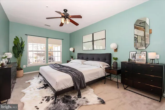 a bedroom with a bed mirror and a window