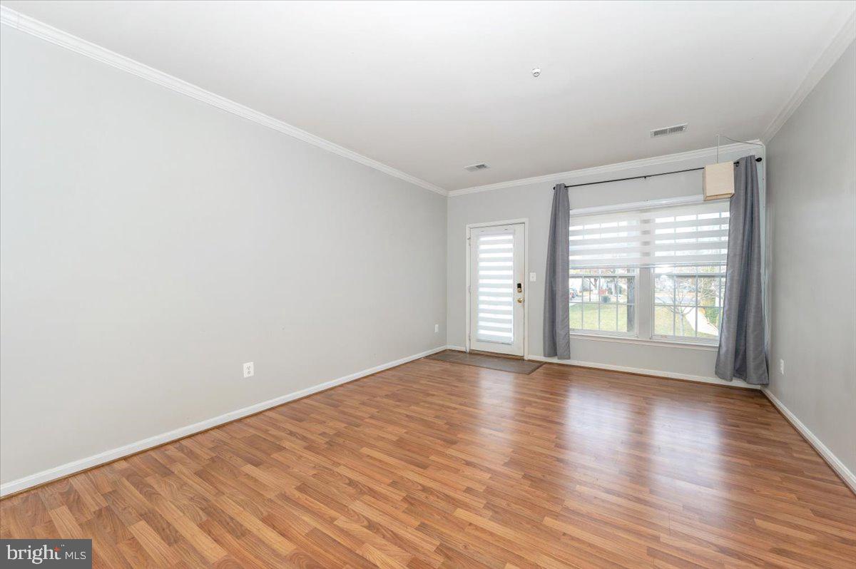 1683 Fallowfield Court Crofton, MD 21114 - Photo 5 of 36 a view of an empty room with wooden floor and a window