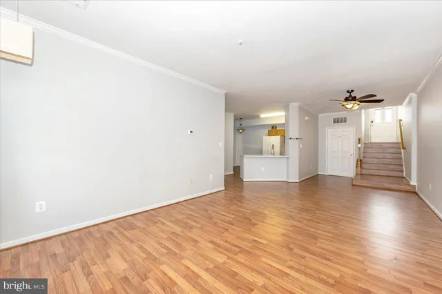 a view of a big room with wooden floor and windows