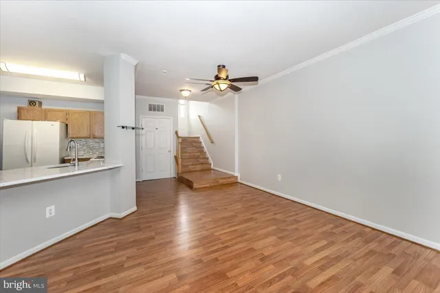 a view of a kitchen with wooden floor and a ceiling fan