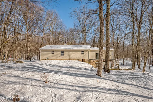 a view of a house with a yard covered with snow