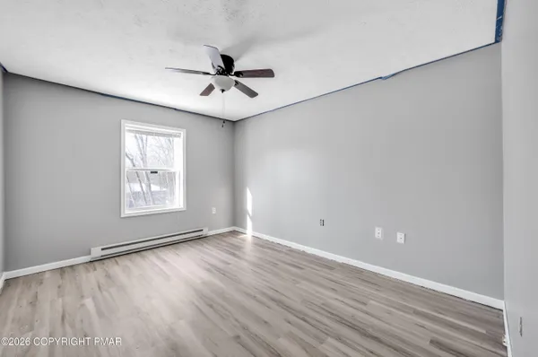 wooden floor in an empty room with a window