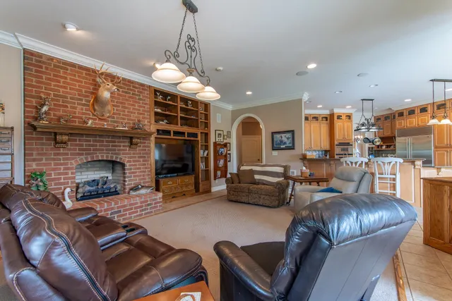 a living room with furniture kitchen view and a fireplace