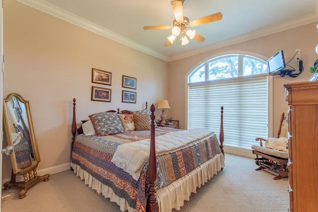 a bedroom with a bed a couch and a chandelier
