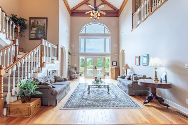 a living room with furniture large window and wooden floor