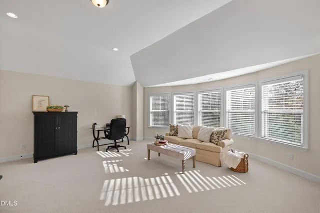a dining room with furniture large windows and wooden floor