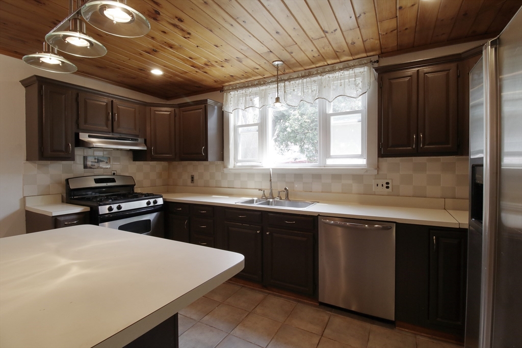 100 Ridge Street Fall River, MA 02721 - Photo 7 of 22 a kitchen with stainless steel appliances a sink stove and cabinets