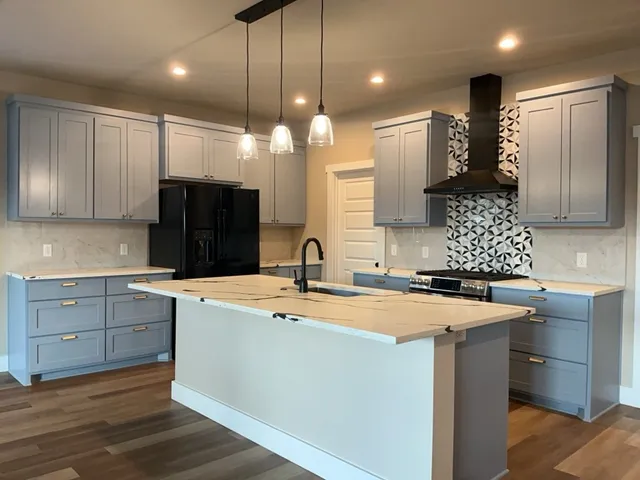 a kitchen with a sink a refrigerator and cabinets