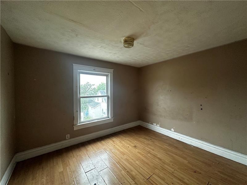 801 Butler Avenue New Castle, PA 16101 - Photo 7 of 8 an empty room with wooden floor and windows