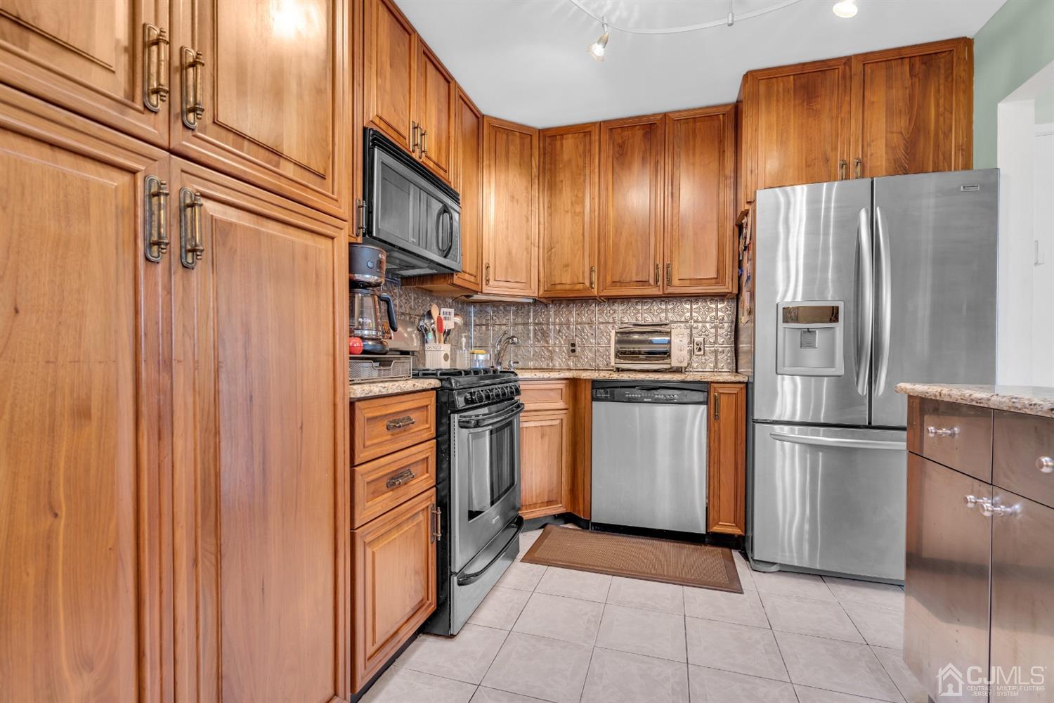 69 Stony Road Edison, NJ 08817 - Photo 11 of 33 a kitchen with cabinets and stainless steel appliances