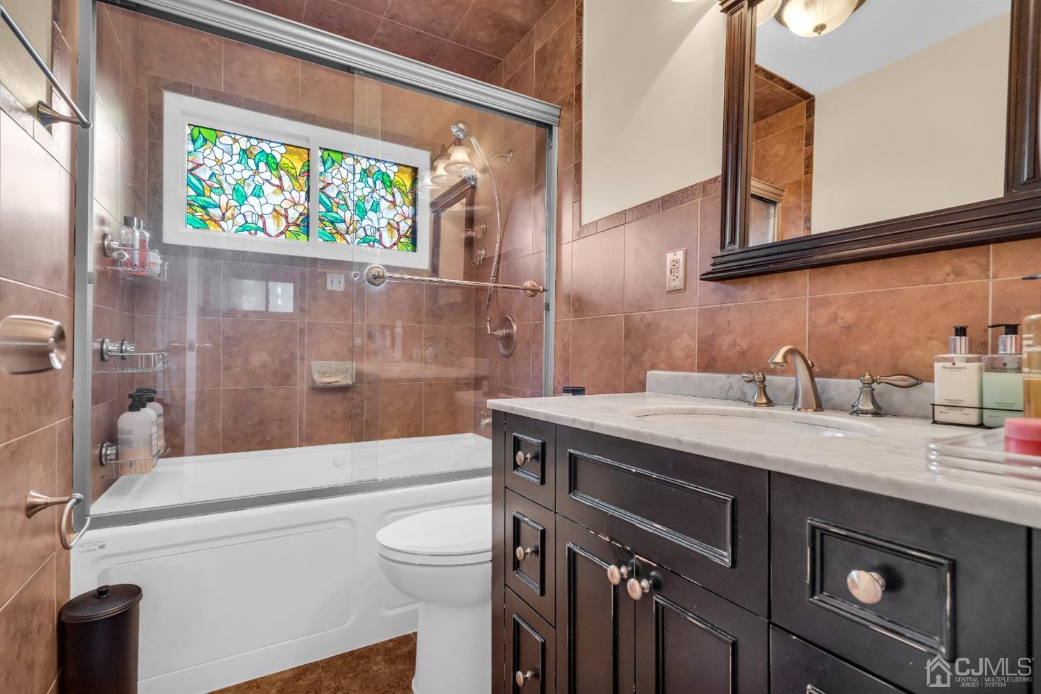 69 Stony Road Edison, NJ 08817 - Photo 22 of 33 a bathroom with a granite countertop sink a toilet a mirror and bathtub