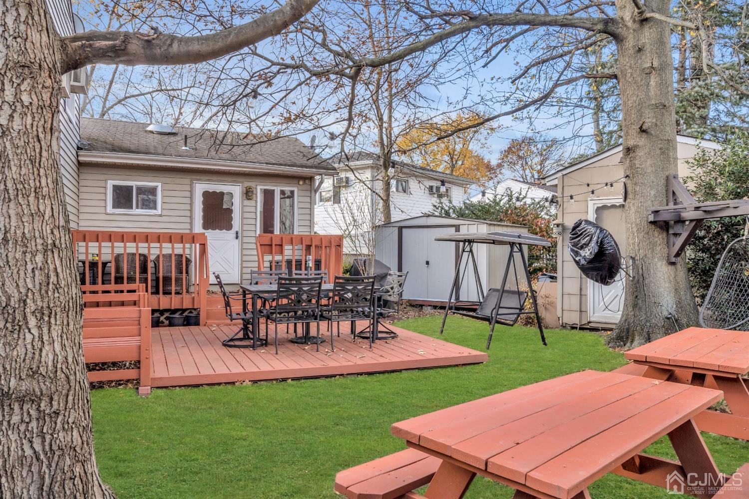 69 Stony Road Edison, NJ 08817 - Photo 30 of 33 a view of a backyard with table and chairs potted plants and a palm tree