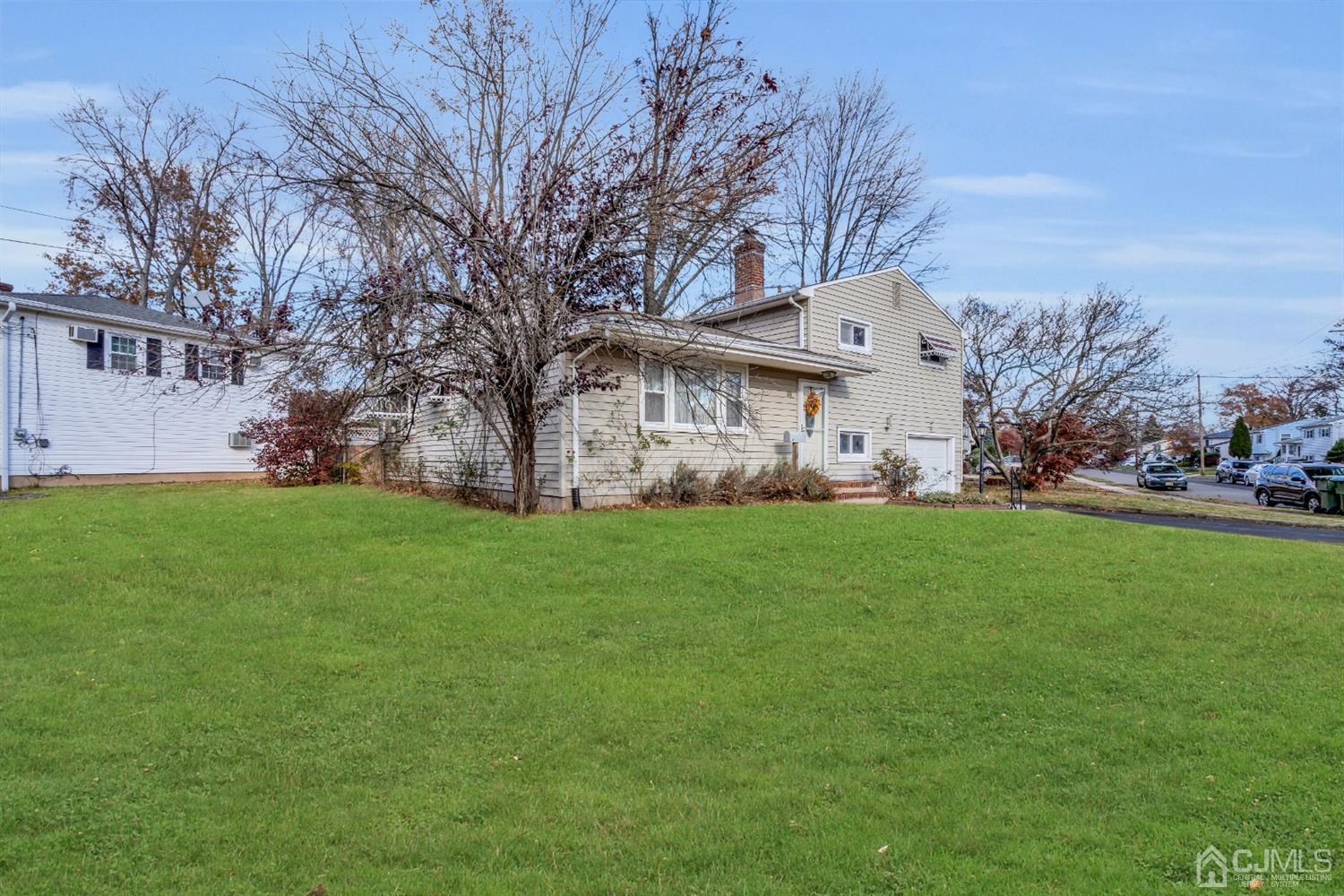 69 Stony Road Edison, NJ 08817 - Photo 33 of 33 a view of a white house with a big yard plants and large trees