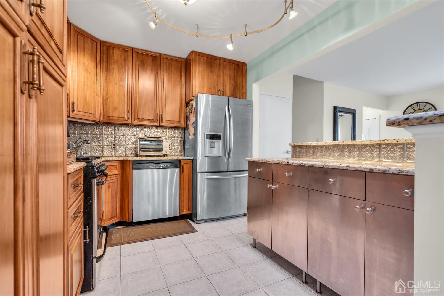 69 Stony Road Edison, NJ 08817 - Photo 10 of 33 a kitchen with granite countertop a refrigerator and a sink