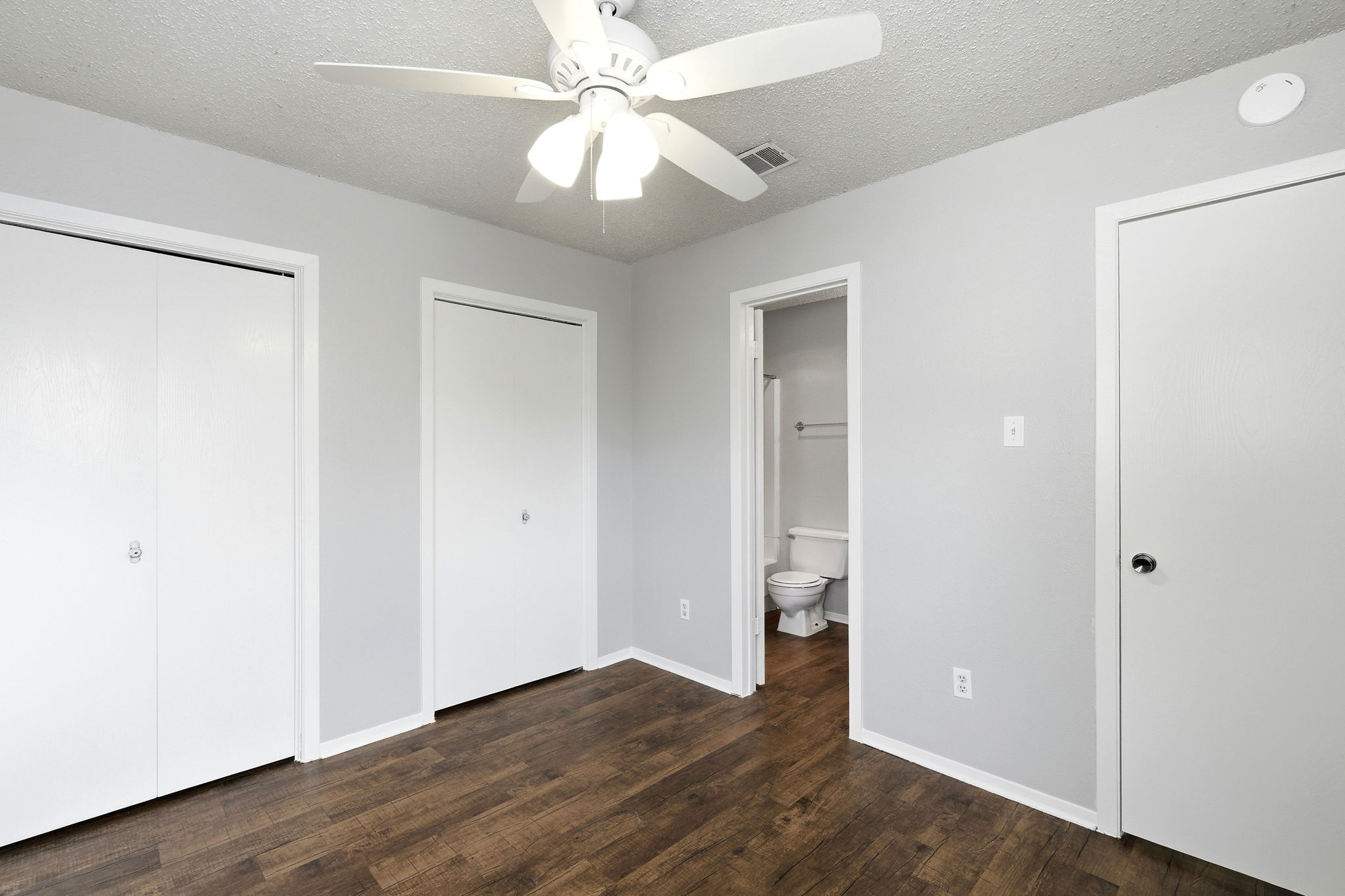 2511 Howellwood Way, Unit A Austin, TX 78748 - Photo 12 of 16 an empty room with wooden floor and ceiling fan