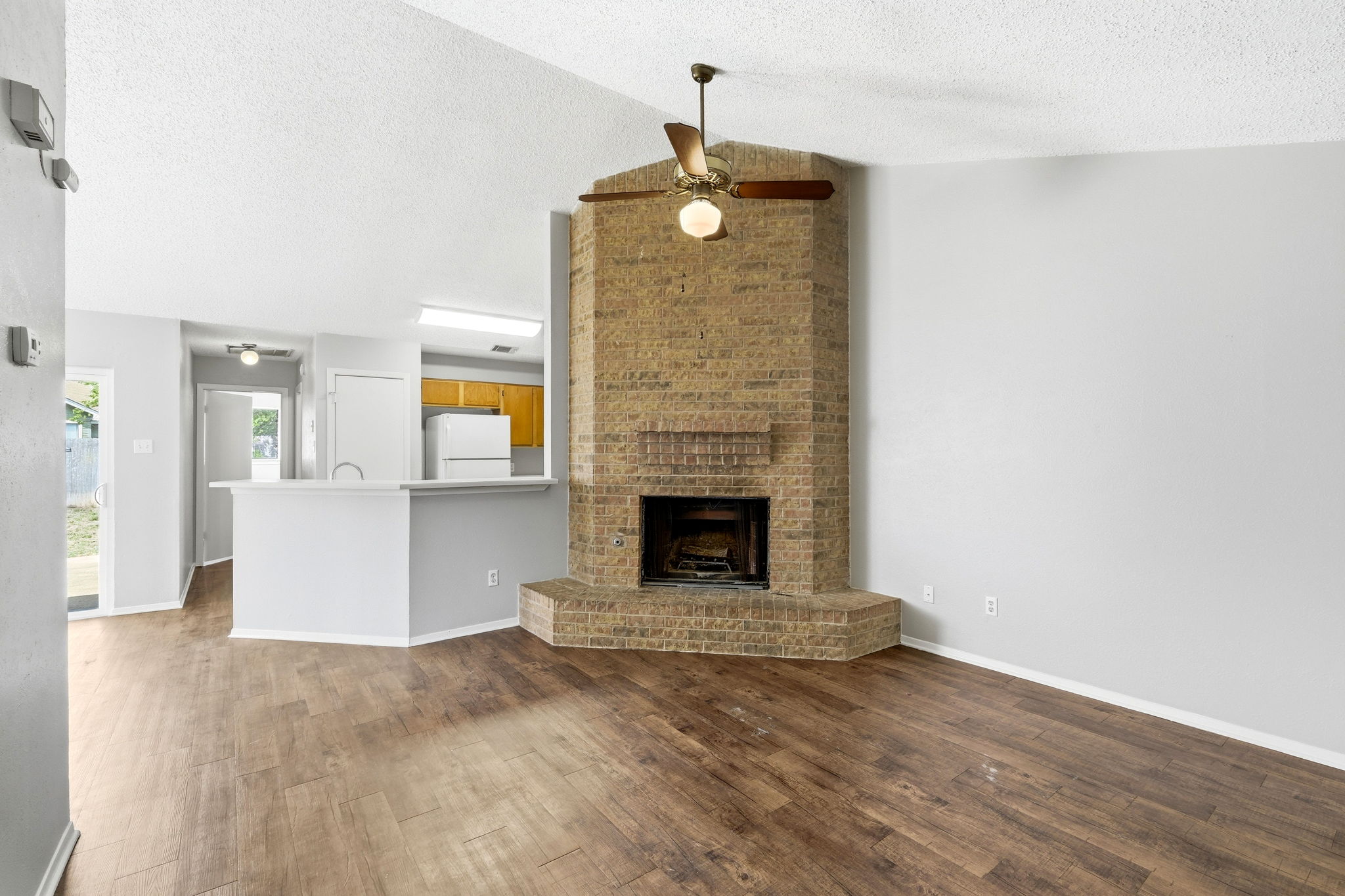 2511 Howellwood Way, Unit A Austin, TX 78748 - Photo 3 of 16 an empty room with wooden floor and fireplace