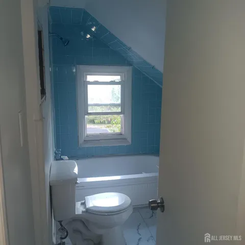 a bathroom with a granite countertop toilet a sink and bathtub