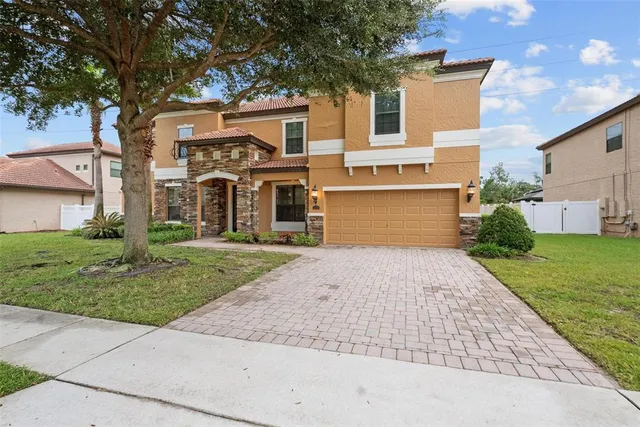a front view of a house with a yard and a garage