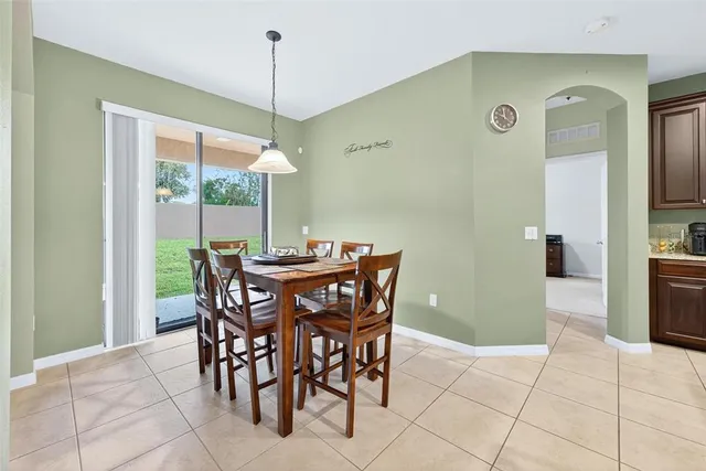 a living room with furniture a dining table and a refrigerator