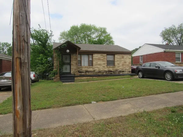a front view of a house with a garden and yard