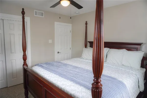 a bedroom with a bed and a chandelier fan