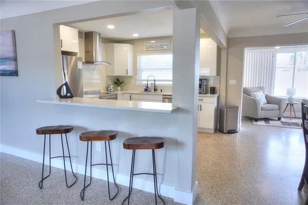a kitchen with stainless steel appliances kitchen island wooden cabinets and dining table