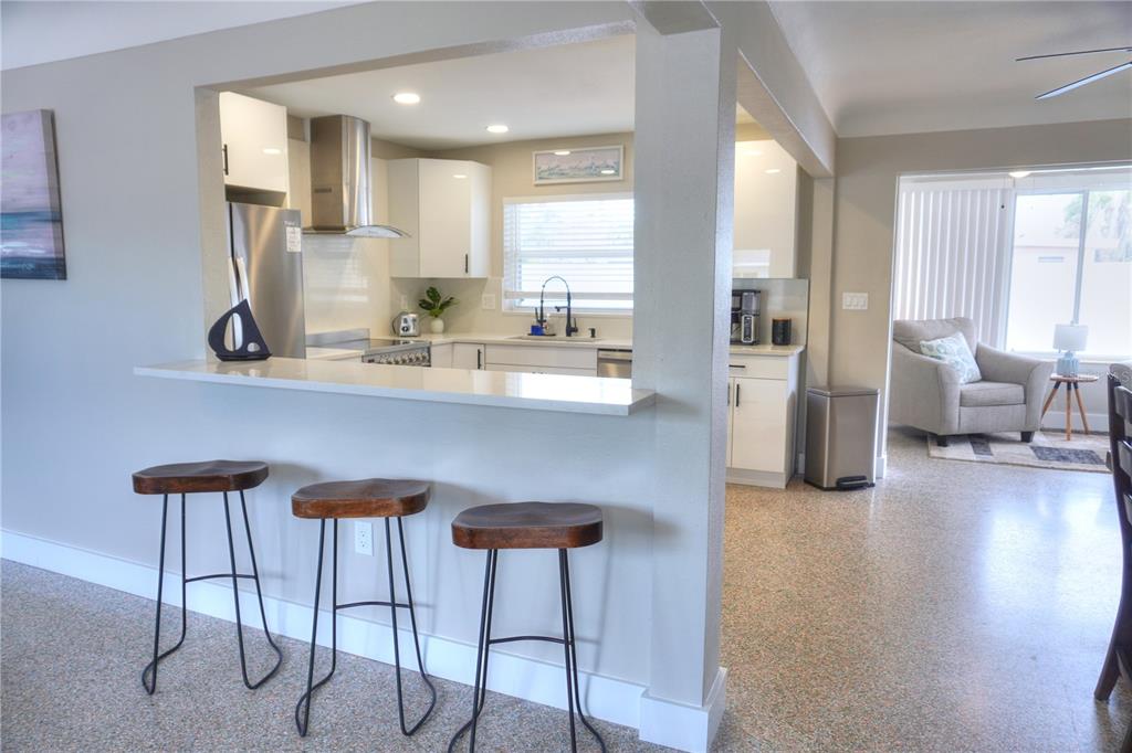 104 163rd Avenue Redington Beach, FL 33708 - Photo 5 of 22 a kitchen with stainless steel appliances kitchen island wooden cabinets and dining table