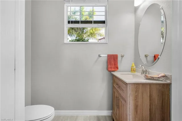 a bathroom with a granite countertop sink mirror vanity and toilet