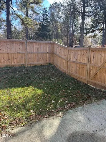 a view of a backyard with wooden fence