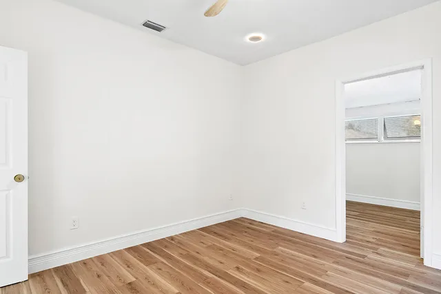 a view of an empty room with wooden floor