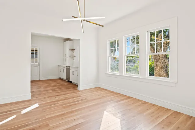 a view of empty room with wooden floor and window