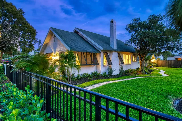 a view of a house with a big yard and potted plants