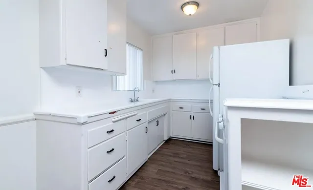 a kitchen with granite countertop white cabinets and white appliances