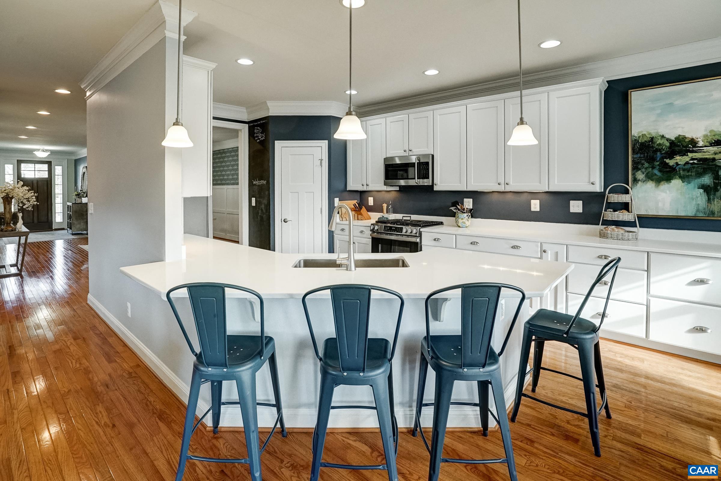 7652 Birchwood Hill Road Crozet, VA 22932 - Photo 15 of 64 a kitchen with stainless steel appliances kitchen island granite countertop a dining table chairs and a refrigerator