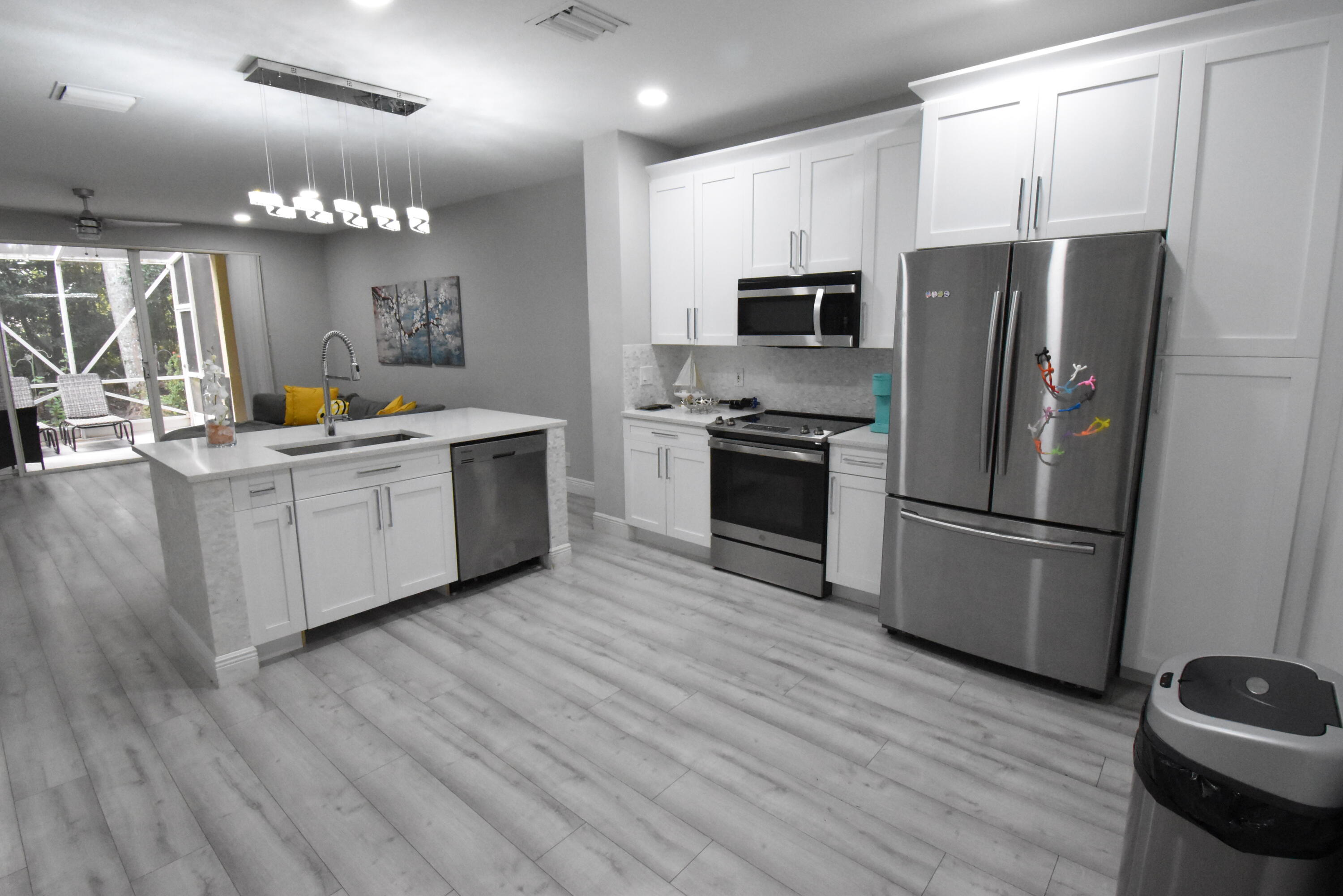 a kitchen with stainless steel appliances a refrigerator sink and wooden floor