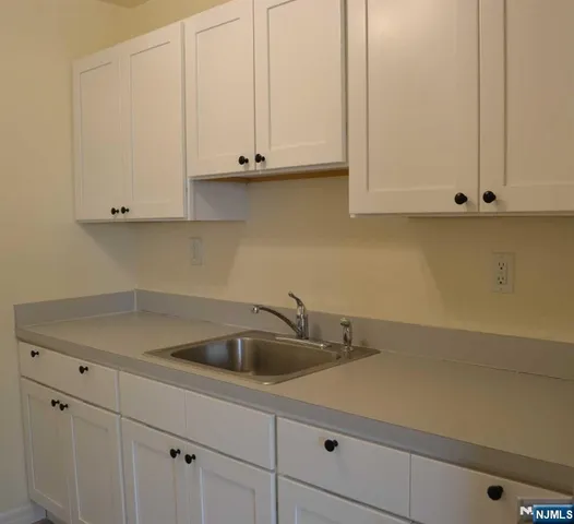 a kitchen with white cabinets and a sink
