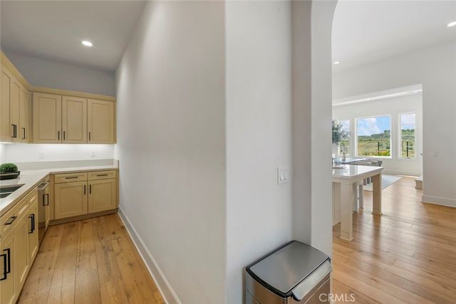 a large kitchen with stainless steel appliances a large counter top a stove a chimney a sink and entryway