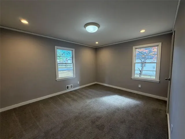 an empty room with windows and closet