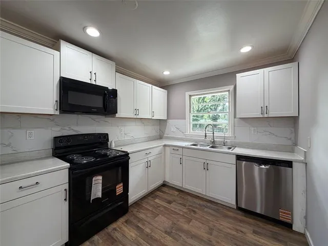 a kitchen with a sink stove and microwave