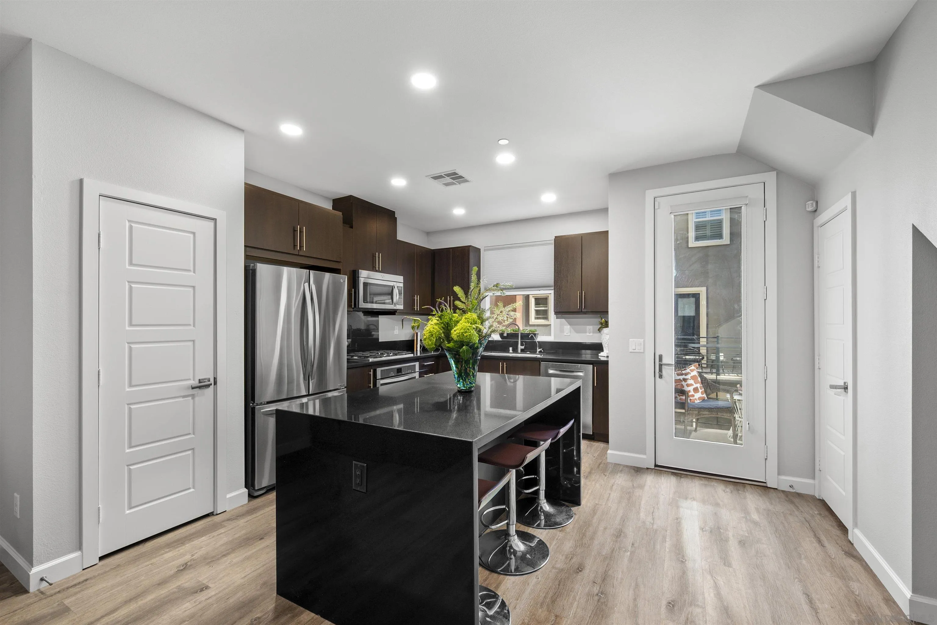 7834 Inception Way San Diego, CA 92108 - Photo 16 of 62 a kitchen with stainless steel appliances kitchen island granite countertop a refrigerator and a stove top oven