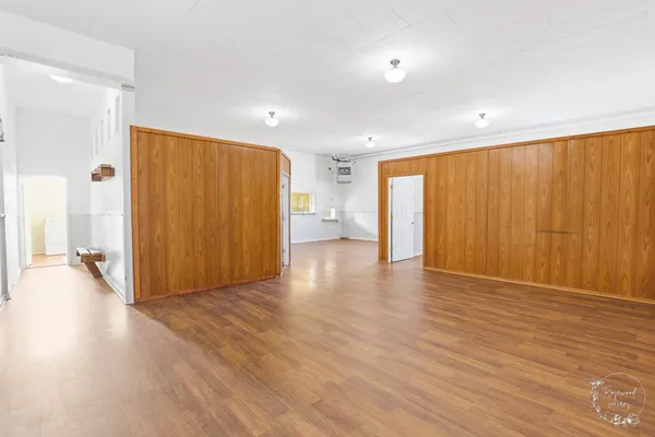 a view of an empty room with wooden floor