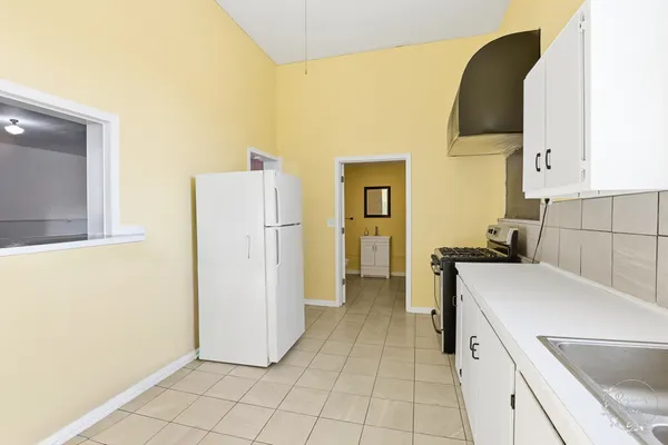 a kitchen with a refrigerator sink and cabinets